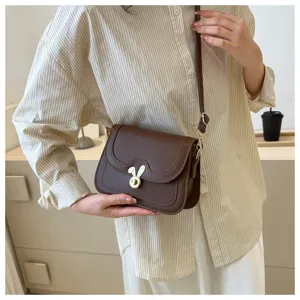 Brown crossbody bag detail featuring cute rabbit ear lock, stylish daily shoulder bag accessory.