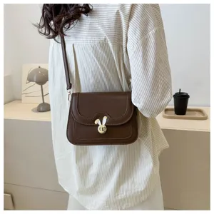 Brown PU leather crossbody bag detail featuring cute rabbit metal lock design and strap.