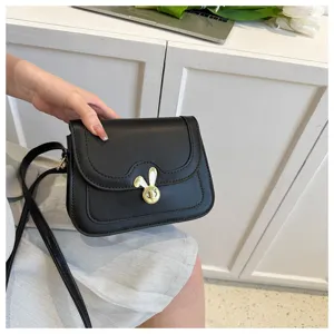 Detail view of a stylish black crossbody bag featuring a cute golden bunny lock and PU leather.