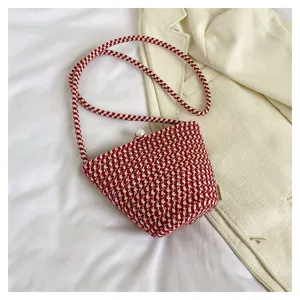 Detailansicht der rot-weißen geflochtenen Eimer Tasche mit feinem Perlenverschluss.