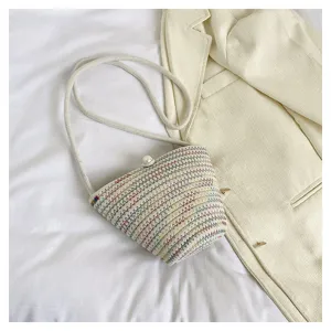 Detailansicht der bunten Stroh-Eimer-Tasche mit Perlenverschluss für den Sommerstrand.