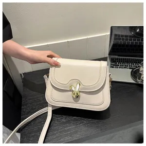 Detailed view of trendy chic cream white shoulder cross body bag with cute bunny ear lock.