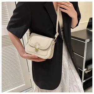 Close-up detail of the elegant beige crossbody bag featuring a cute golden rabbit metal clasp lock.