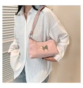 Sac à bandoulière rose avec papillon argenté, tissu texturé, sac à main de style chic.