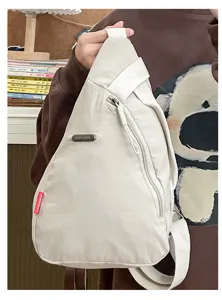 Vista detallada del bolso cruzado beige casual, tela resistente y correa ajustable.