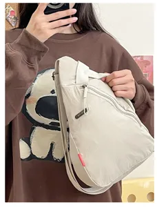 Detalle de bolso bandolera de nailon beige, bolso de pecho casual para deporte y uso diario.