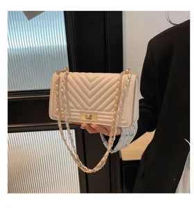 Sac bandoulière matelassé à chaîne et fermoir métallique, design blanc chic et élégant.