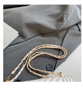 Gros plan détaillé d'un sac bandoulière matelassé blanc élégant avec une chaîne dorée.