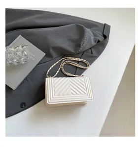 Sac bandoulière matelassé blanc avec chaîne chic, style d'épaule minimaliste et élégant.