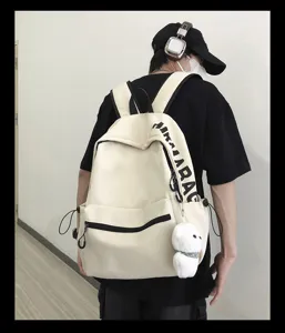 Detailed view of the minimalist solid color backpack worn by model, showing side pocket details.
