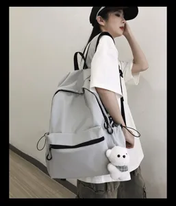 Korean style solid color casual backpack with cute bear pendant, simple student school bag.