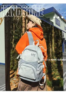 Dettaglio zaino con scomparti multipli, tessuto resistente e comode tasche laterali in rete.