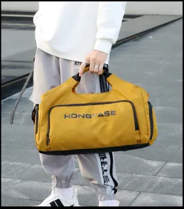 Detailed close-up view of the yellow travel duffel bag showing texture, straps, and front print.