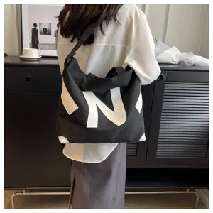 Canvas shoulder bag for women, casual tote design with contrast letter print, stylish and spacious.