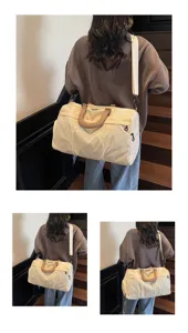 Detail view of a large capacity travel duffel bag with dual handles and shoulder strap.
