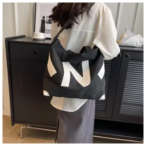 Casual black canvas shoulder bag with white letter design, large capacity tote for daily use.
