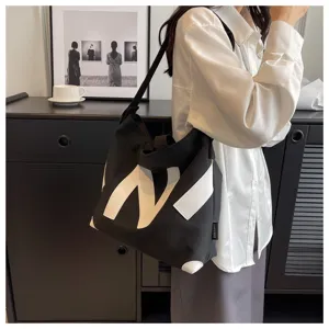 Women black canvas tote bag, casual daily shoulder bag with stylish white letter N design.
