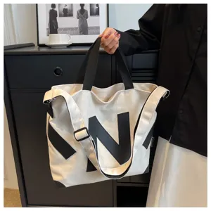 Minimalist canvas tote bag for women, stylish black and white shoulder crossbody bag.