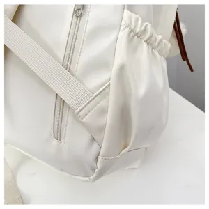 White casual backpack detail view showing side pocket and zipper design for everyday use