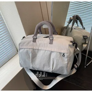Detailed view of large capacity fitness duffel bag with grey grid pattern and handles.