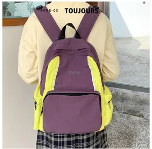 Backpack detail showing trendy purple and yellow color block design with multiple pockets.