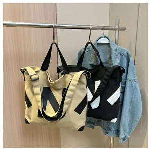 Casual canvas tote bag for women, large capacity shoulder crossbody bag with stylish letter design.