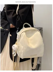 Detailed view of white casual commuter backpack with cute fluffy pendant, perfect for daily use.