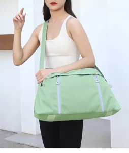 Detailed view of the light green large capacity sports gym bag with zipper pockets and straps.