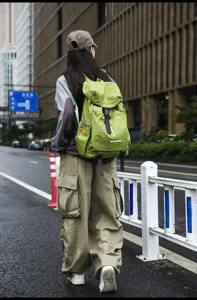 Outdoor casual green canvas backpack detail showing straps, buckle closure and spacious wear.