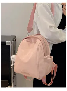 Pink commuter backpack with wide straps and cute fluffy charm for daily travel and school.