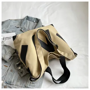 Canvas tote shoulder bag for women, stylish beige design with black letter M accent.