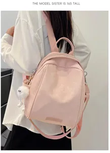 Pink casual backpack detail showing spacious capacity and cute fluffy pendant charm.