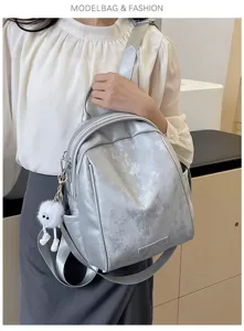 Detailed view of the stylish silver women backpack, featuring smooth material and cute pendant.