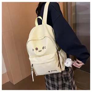 Cute canvas backpack for school and casual travel with cartoon face and plush charm.