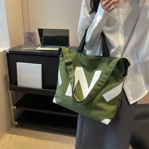Green canvas tote bag for women with stylish letter N design, casual shoulder bag.
