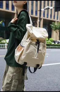 Lightweight casual backpack featuring drawstring flap closure and side pocket detail.