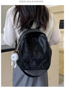 Stylish black PU leather backpack with cute white plush keychain for women and students.