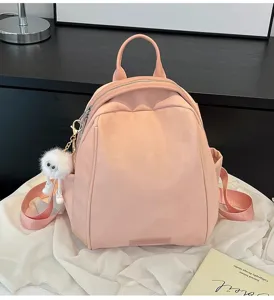Pink casual backpack for women, large capacity travel school bag with cute plush pendant.