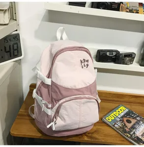 Dettaglio zaino casual rosa con tasche multiple e tasche laterali in rete.