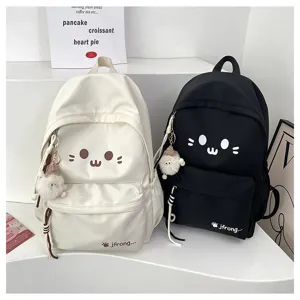 Detailed view of cute cat face canvas school backpack with plush pendant, student casual bag.
