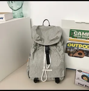 Detailed view of the casual light grey travel backpack with drawstring flap and buckles.