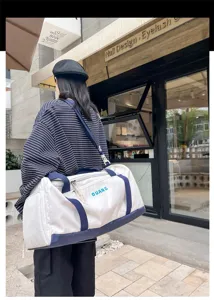 Outdoor detail view of a stylish white and blue waterproof gym travel duffel bag.