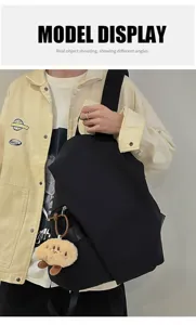 Zaino nero impermeabile in dettaglio, borsa casual alla moda con ciondolo di peluche carino.