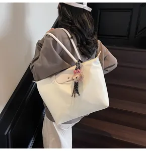 Grosse Nylon-Shopper-Tasche mit Lederklappe und niedlichem Pluesch-Anhaenger fuer Pendler.