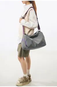 Stylish grey gym duffel bag with purple straps, ideal for sports, travel and fitness.