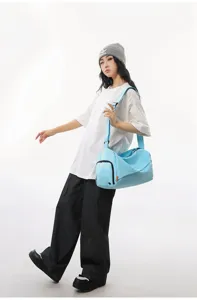 Light blue gym duffel bag detail showcasing convenient crossbody strap and wet-dry separation.