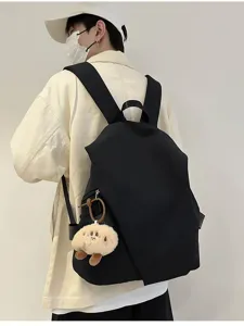 Zaino nero minimalista idrorepellente in dettaglio con un ciondolo in peluche carino.