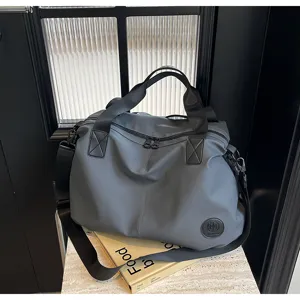 Grey nylon large capacity travel duffel bag with shoulder strap, casual commuter tote design.