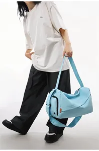Light blue gym duffel bag detail, showing waterproof fabric, crossbody strap and side pocket design.