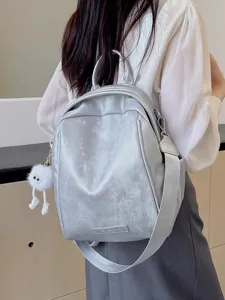 Stylish silver backpack for women, large capacity commuter travel school bag with cute plush charm.